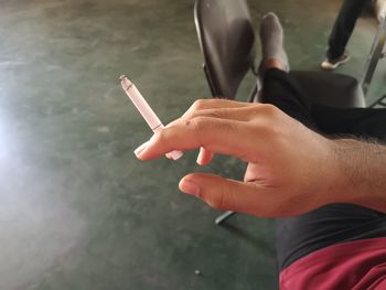 Midsection of man smoking cigarette