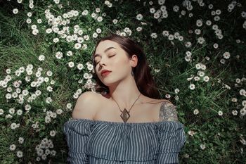 Beautiful woman lying down on flowering plants