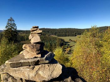 Stack of rocks against clear blue sky