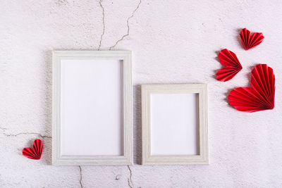 Paper red do-it-yourself hearts around empty photo frames on a concrete background. valentine's day.