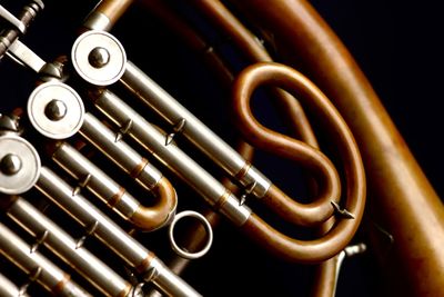 Cropped image of french horn against black background