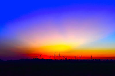 Silhouette of wind turbines at sunset