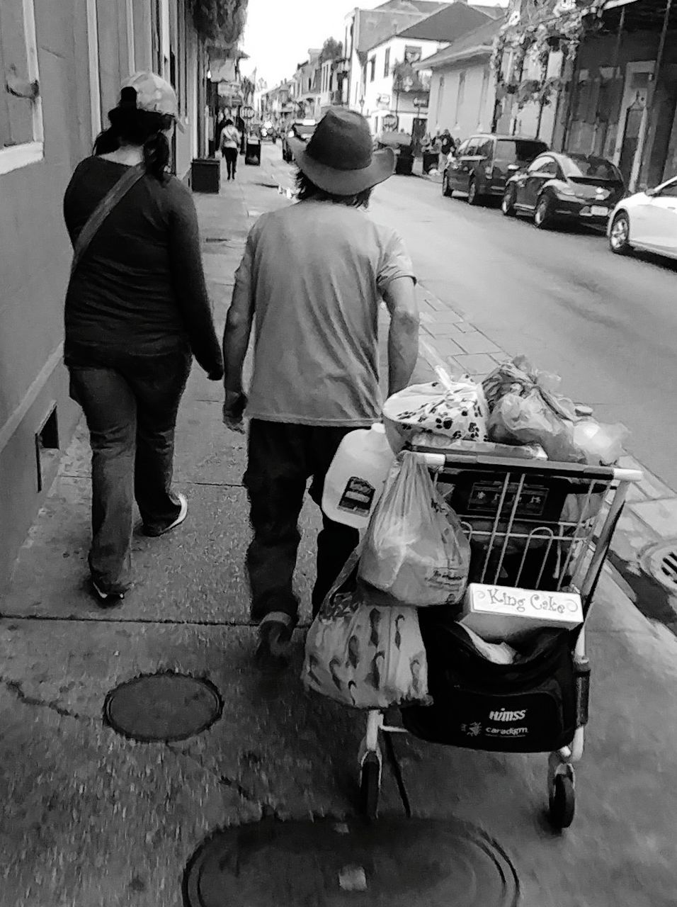 REAR VIEW OF PEOPLE WALKING ON STREET