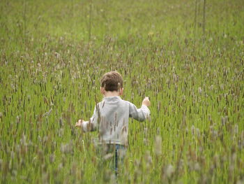 Rear view of boy standing on field