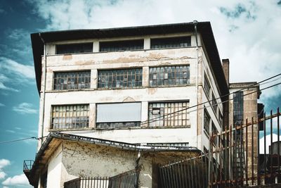 Low angle view of abandoned building against sky