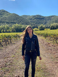 Portrait of young woman standing on field