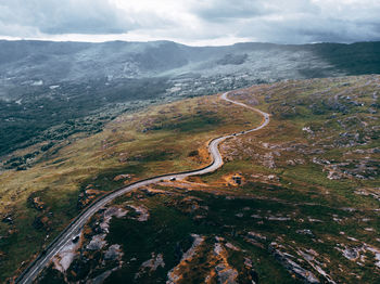 Mountain road against cloudy sky