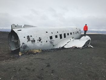 Man standing on airplane against sky