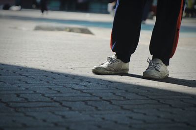 Low section of man standing on footpath