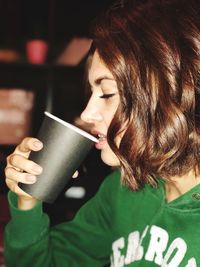 Close-up of woman drinking from disposable cup