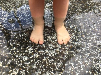 Low section of child standing in water