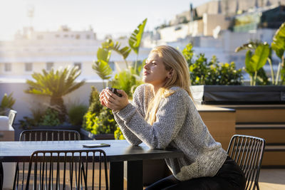 Young woman sitting on table at cafe