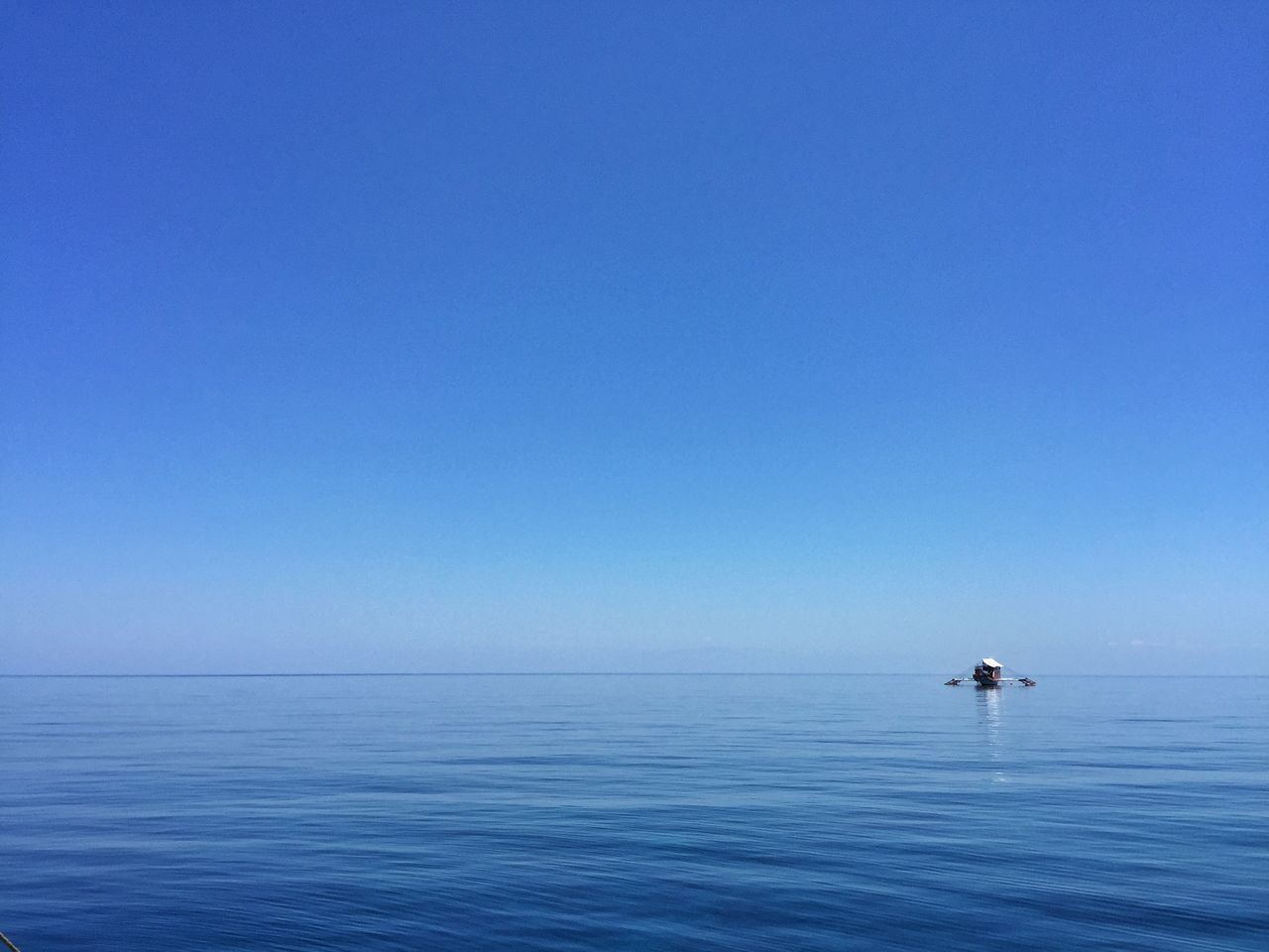 sea, water, copy space, clear sky, blue, waterfront, horizon over water, tranquil scene, tranquility, scenics, beauty in nature, nature, rippled, nautical vessel, idyllic, seascape, transportation, calm, ocean, boat