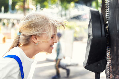 Side view of young woman using mobile phone