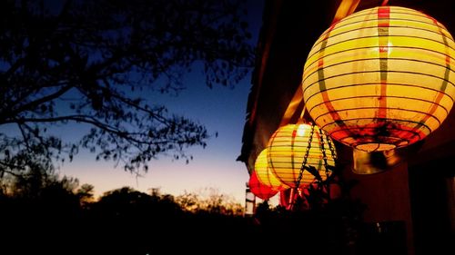 Low angle view of illuminated lantern against sky at night