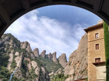 Low angle view of arch bridge against cloudy sky