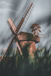 Traditional windmill on field against sky