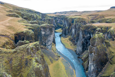Winding blue riverbed flowing between rocks in iceland, natural amazing landscape. drone shot.