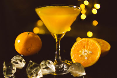 Close-up of orange juice on table against black background