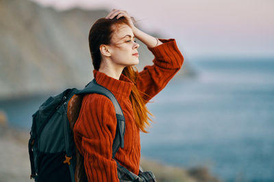 Young woman looking away while standing in sea