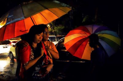 People holding multi colored umbrella