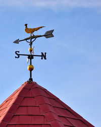 Low angle view of weather vane against sky