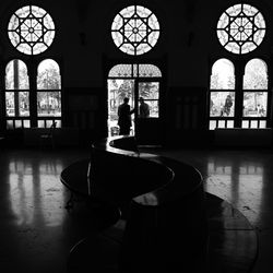 Silhouette man standing by window in building