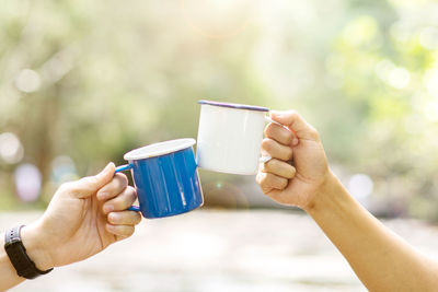 Cropped image of hands toasting coffee cup