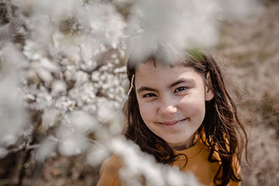 Portrait of smiling girl surrounded by blooming trees