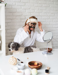 Self care. young caucasian woman wearing bathrobes doing spa procedures with her dog