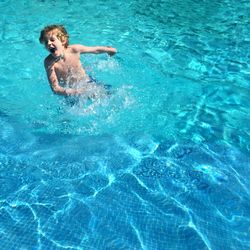 High angle view of boy playing in swimming pool