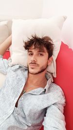 Portrait of young man relaxing on sofa at home