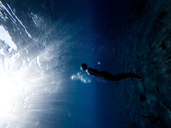 Low angle view of woman swimming in sea