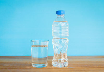 Glass of water on table against blue background