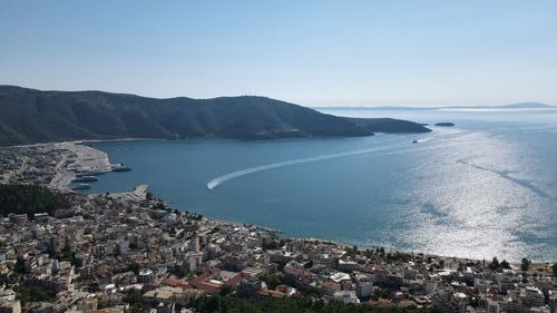 Aerial view of city by sea against sky