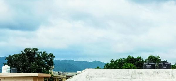 Low angle view of trees and building against sky