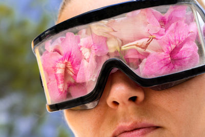 Woman wearing protective googles filled up with flowers