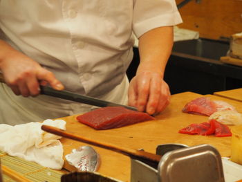 Midsection of man preparing food on cutting board