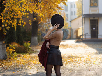 Rear view of woman standing against trees