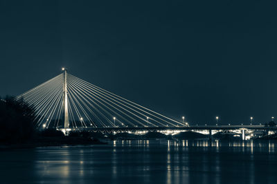 Suspension bridge over river at night