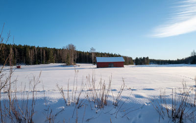 Scenic view of snow covered field against sky