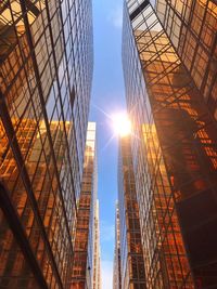 Low angle view of modern buildings against sky during sunny day