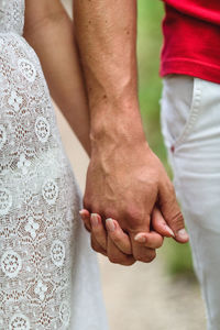 Midsection of couple holding hands