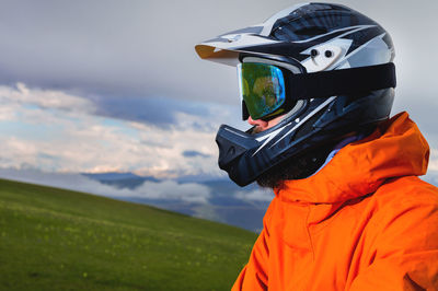 Close-up portrait of a man on a mountain bike standing in a green field and looking away. mountain
