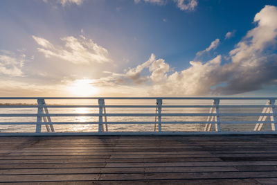 Pier over sea against sky during sunset