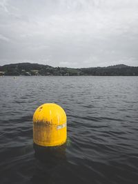 Close-up of yellow floating on river against sky