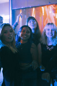 Portrait of happy young multiracial women enjoying together at nightclub