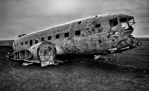 Old abandoned truck on airplane against sky