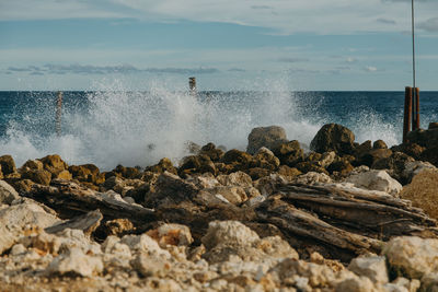 Rocks by sea against sky