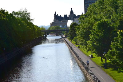 Bridge over river in city against sky